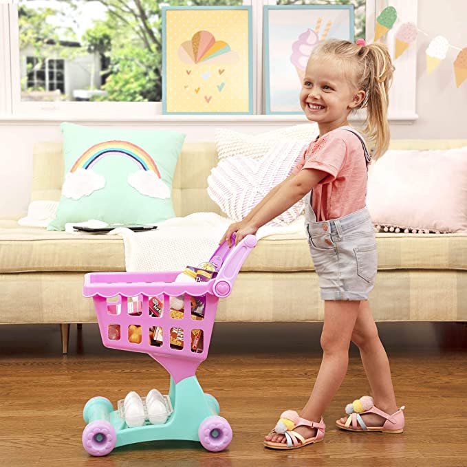 A pink toy shopping cart for the toddler activity 'grocery shopping.'